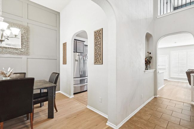 Dining space with arched walkways, a towering ceiling, and light wood finished floors | Image 5