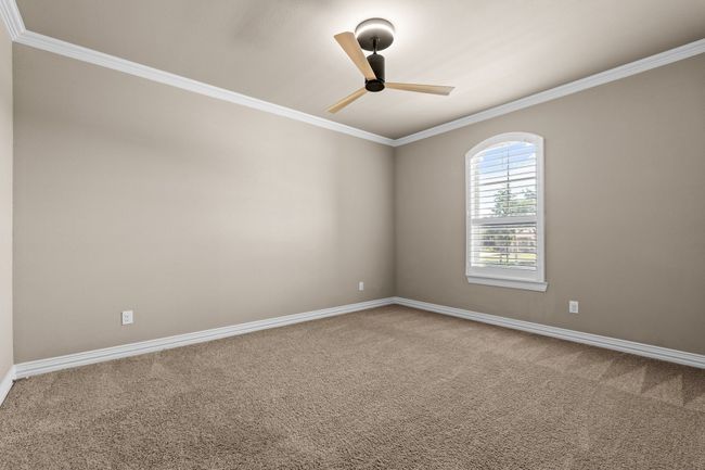 Empty room featuring crown molding, carpet floors, and a ceiling fan | Image 30