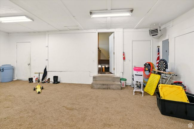 Basement featuring carpet floors, electric panel, and a heating unit | Image 16