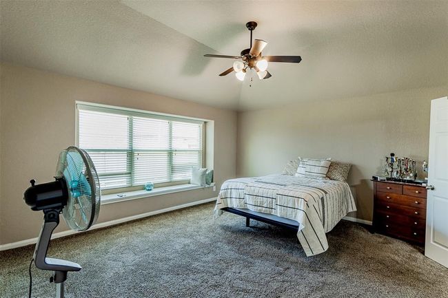 Large primary bedroom with a bay window with seating space. | Image 15