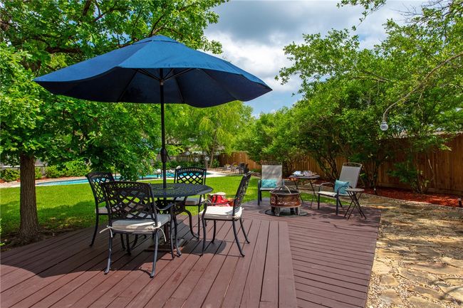 Wooden deck with a fenced backyard, a fenced in pool, a yard, and a fire pit | Image 27