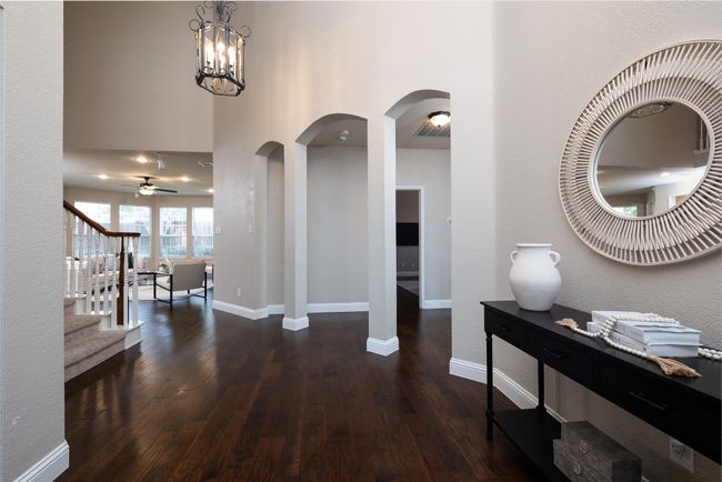 Foyer with hardwood / wood-style flooring, stairway, ceiling fan, and arched walkways | Image 5