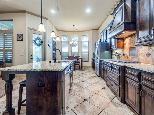 Kitchen with a sink, appliances with stainless steel finishes, ornamental molding, premium range hood, and decorative backsplash | Image 11
