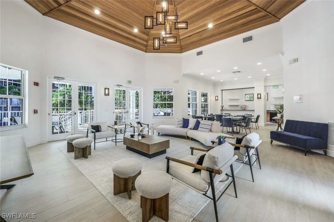 Living room with wooden ceiling, a towering ceiling, light wood-style floors, recessed lighting, and french doors | Image 24