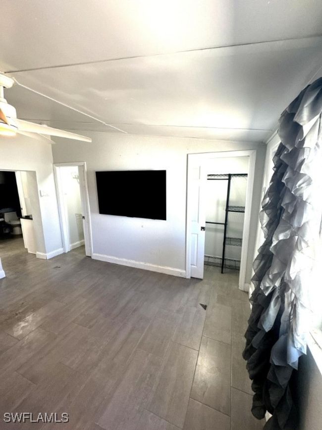 Unfurnished living room with baseboards, wood finished floors, and a ceiling fan | Image 12