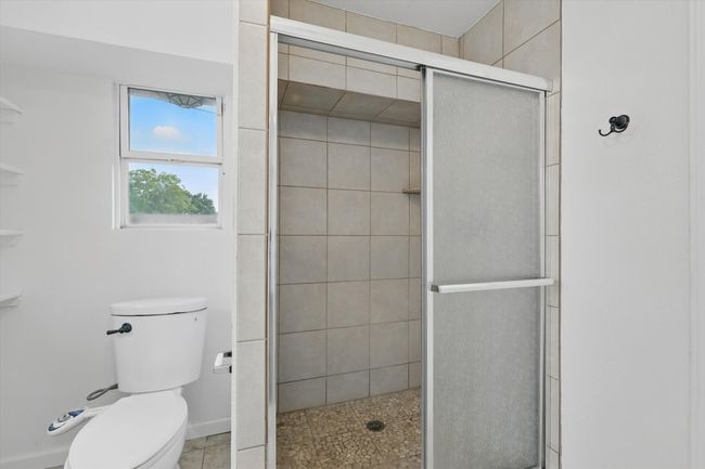 Bathroom featuring toilet and a stall shower | Image 15