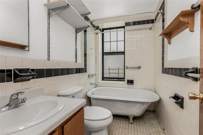 Bathroom with tile walls, a freestanding bath, and vanity | Image 18