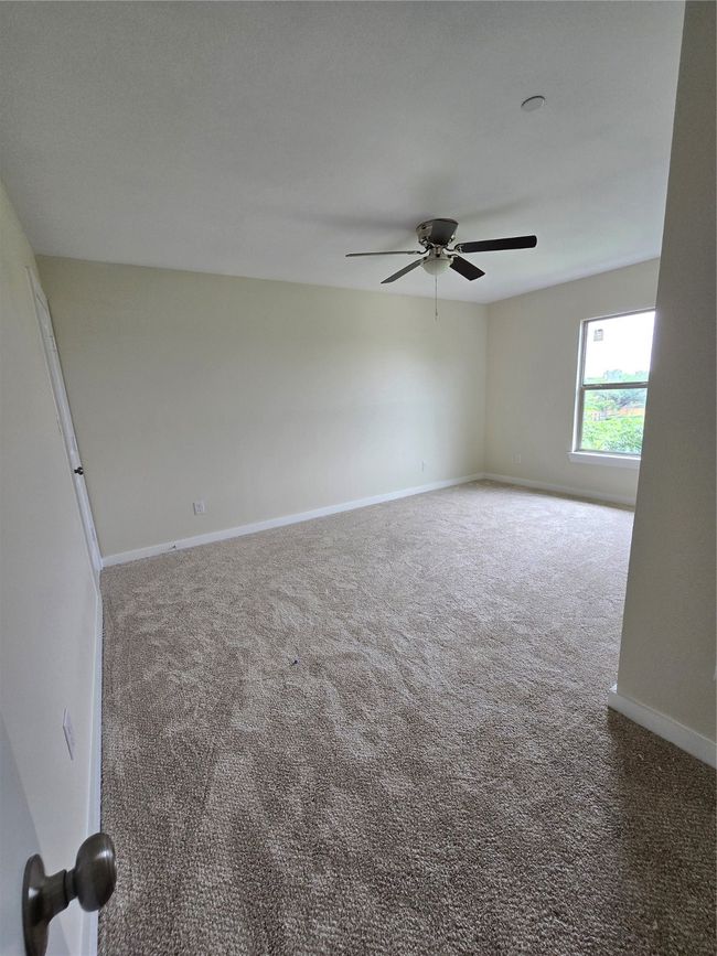 Carpeted empty room featuring baseboards and ceiling fan | Image 30