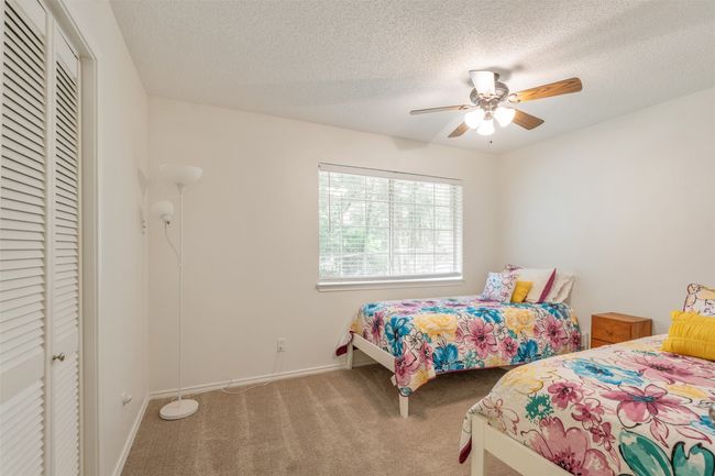 Bedroom featuring carpet floors, a closet, a textured ceiling, and a ceiling fan | Image 20
