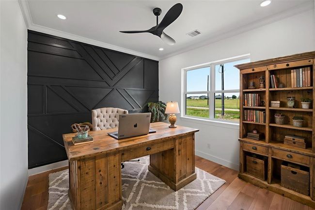 Stylish and functional office space with modern accents and a serene view, perfect for productivity. DIGITALLY STAGED | Image 6