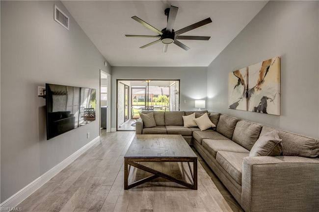 Living room featuring ceiling fan, light hardwood / wood-style flooring, and vaulted ceiling | Image 4