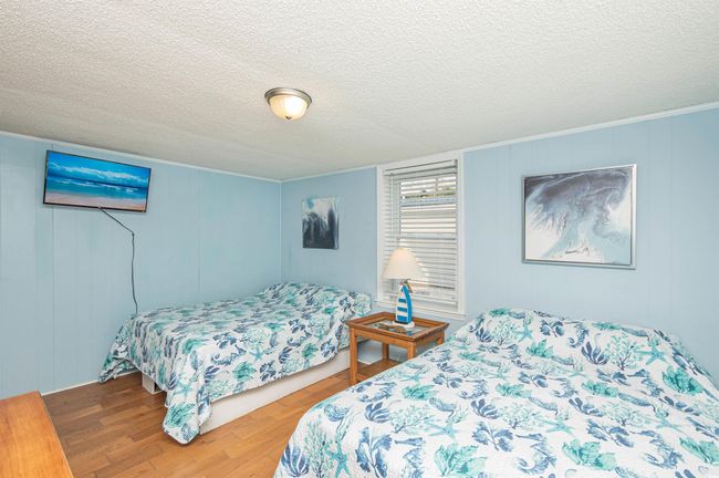 Bedroom featuring wood finished floors, a textured ceiling, a decorative wall, and ornamental molding | Image 16