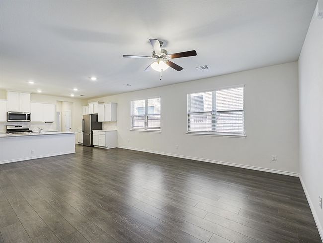 Unfurnished living room featuring ceiling fan, dark wood finished floors, and recessed lighting | Image 6