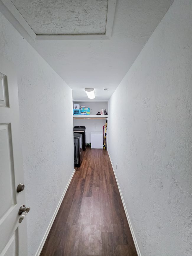 Hall with dark wood-style floors, baseboards, and a textured wall | Image 18
