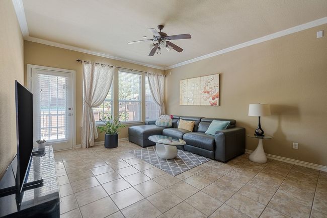 Living area featuring baseboards, ornamental molding, ceiling fan, and light tile patterned flooring | Image 22