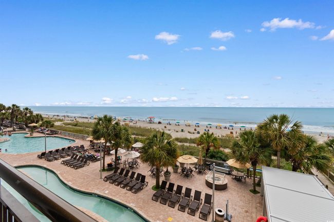Community pool featuring view of water and beach and a patio area | Image 28