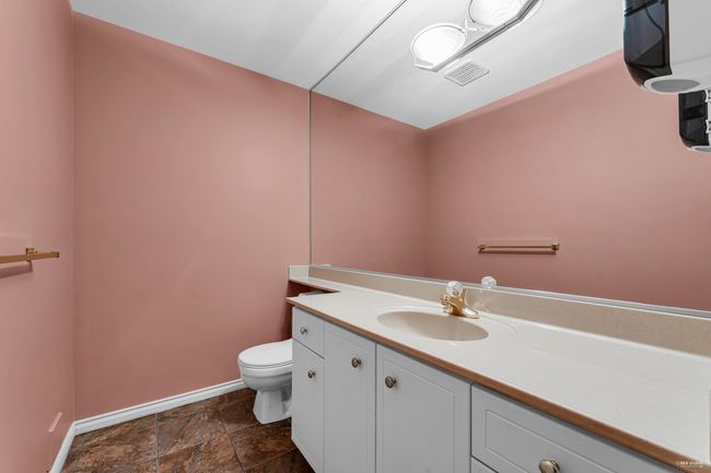 Half bath featuring stone finish floor, vanity, visible vents, toilet, and baseboards | Image 7