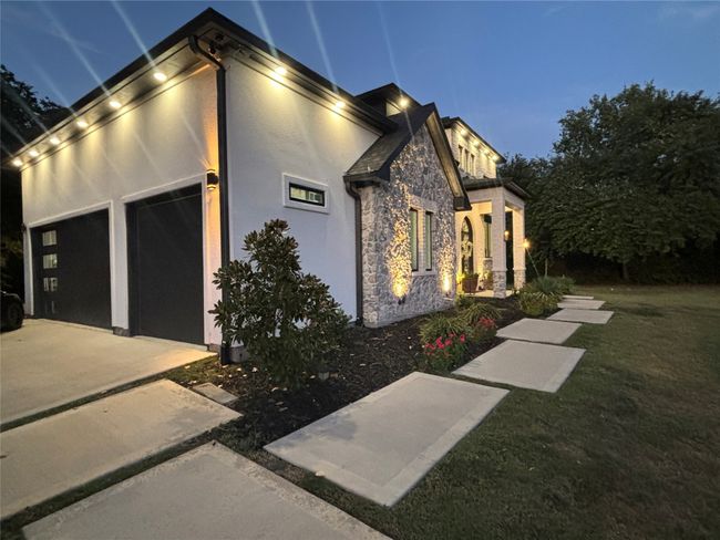 Property exterior at twilight featuring stone siding, stucco siding, and driveway | Image 4