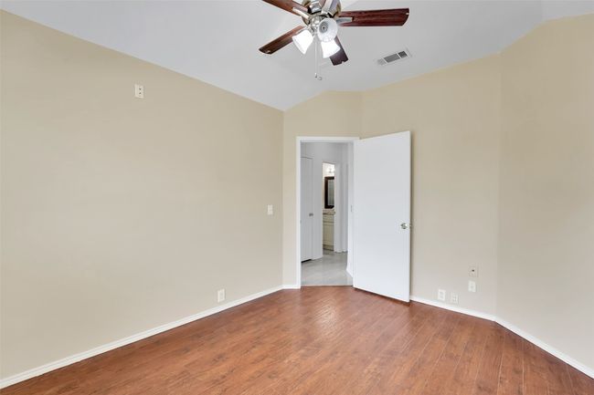 Unfurnished room with hardwood / wood-style floors, vaulted ceiling, and ceiling fan | Image 17