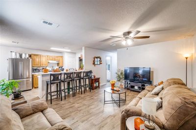 Unit 316 Living room with wood-style vinyl floors, a textured ceiling, and ceiling fan | Image 2