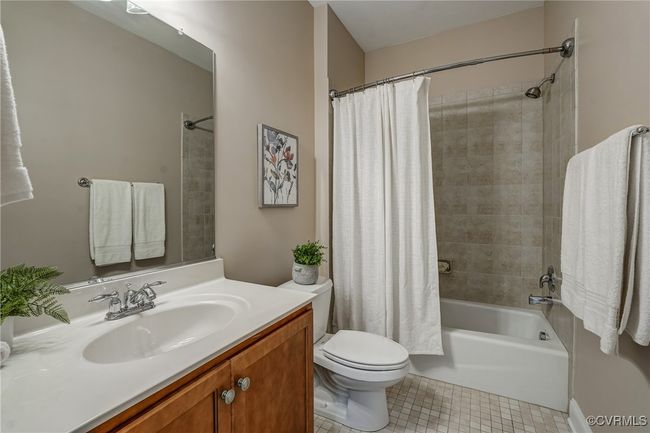 Upstairs full bath featuring tile flooring, a spacious vanity, and a tiled shower—offering a clean, modern finish with practical comfort. | Image 30
