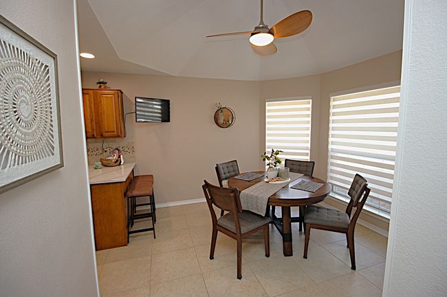 Dining area with light tile patterned floors, a ceiling fan, and baseboards | Image 15