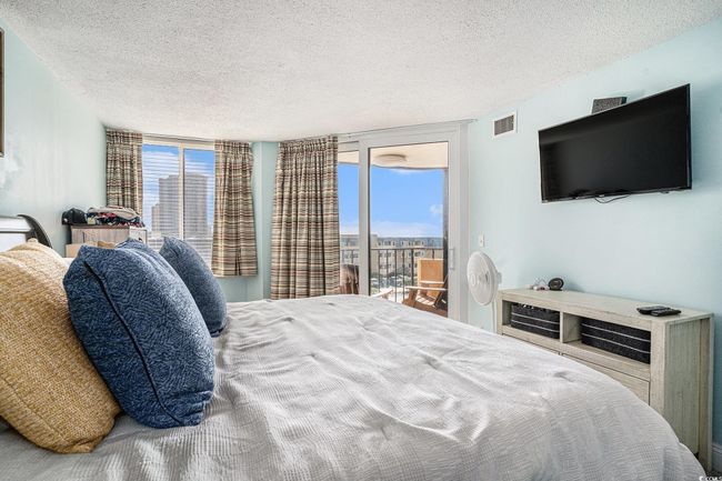 Bedroom featuring a textured ceiling, access to exterior, and expansive windows | Image 16