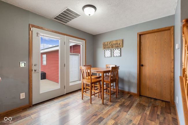 dining area featuring visible vents, a textured ceiling, baseboards, and wood finished floors | Image 15