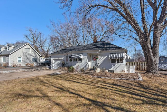 The front yard is relatively large and features a beautiful old tree and some flower beds. | Image 31