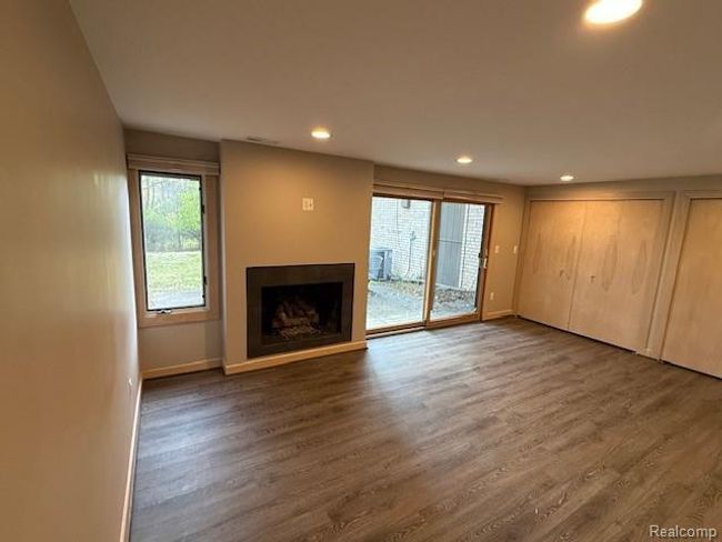 Unfurnished living room with a fireplace, recessed lighting, and dark wood-type flooring | Image 16