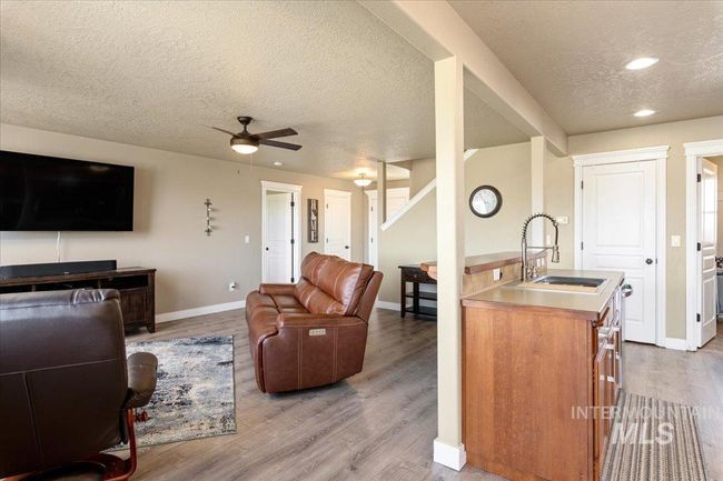 Living room featuring a textured ceiling, a ceiling fan, wood finished floors, and recessed lighting | Image 7