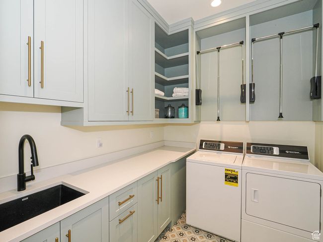 Washroom featuring cabinet space and washing machine and clothes dryer | Image 91