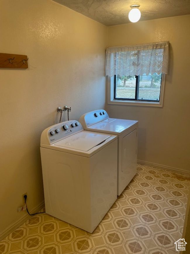 Clothes washing area with a textured ceiling, washer and clothes dryer, and laundry area | Image 15