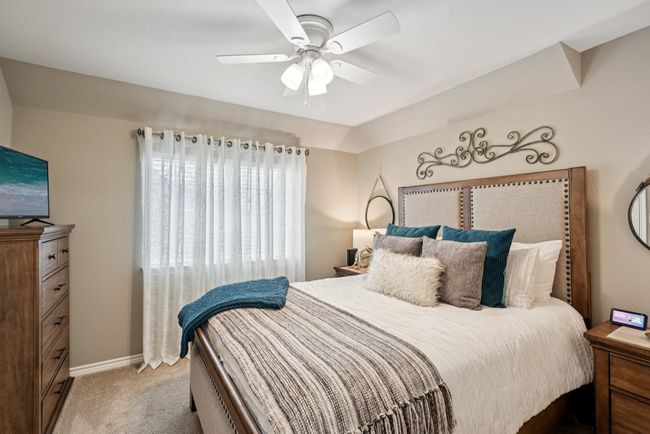 Bedroom featuring light carpet and ceiling fan and a walk in closet. | Image 26