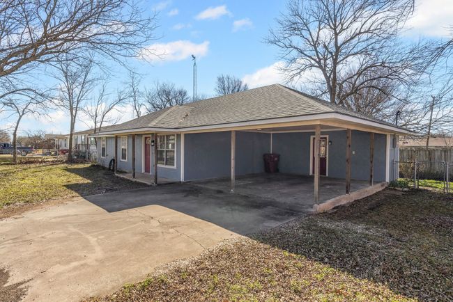 View of side of home featuring siding, a shingled roof, fence, an attached carport, and driveway | Image 27