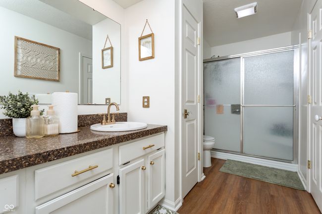 full bath featuring wood finished floors, vanity, and an enclosed shower | Image 23