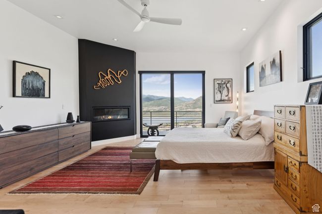 Bedroom featuring a mountain view, light wood-style floors, a large fireplace, access to exterior, and recessed lighting | Image 23