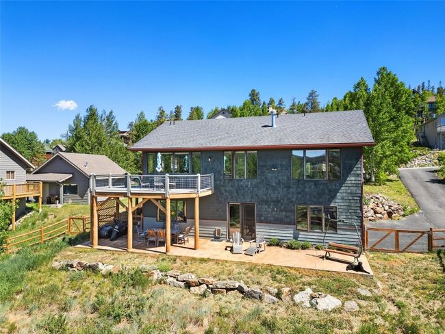 Rear view of house featuring a deck, a patio, a fenced backyard, and roof with shingles | Image 18