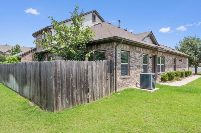 View of home's exterior with cooling unit, brick siding, and roof with shingles | Image 5