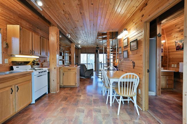 The kitchen and dining areas with bathroom to the right. | Image 67