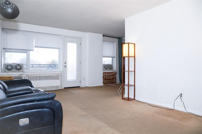 Carpeted living room with radiator | Image 5