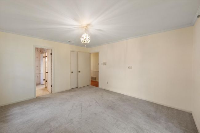 Front bedroom featuring healthy amount of natural light, crown molding, french doors, and a chandelier with bathroom | Image 21