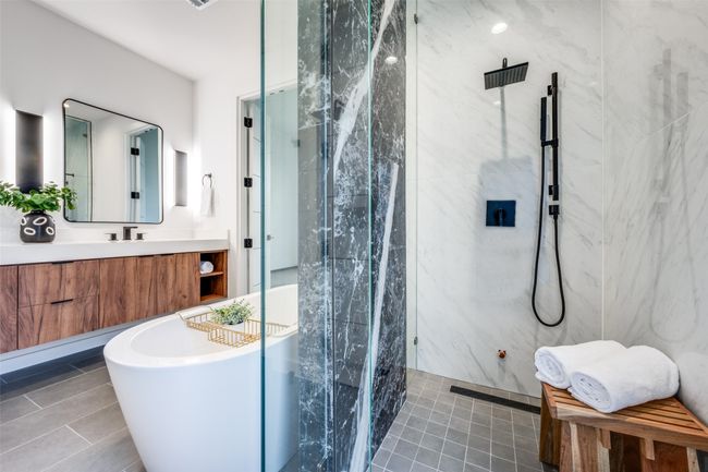 Bathroom featuring a marble finish shower, tile patterned flooring, a freestanding bath, and vanity | Image 14