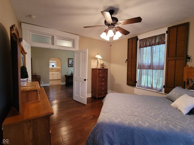 Primary bedroom features original wood shutters, double door entry with trim and original transom, adjoining sitting room, hardwoods, and original headboard to the house that has been restored. The headboard will remain with the house. | Image 40