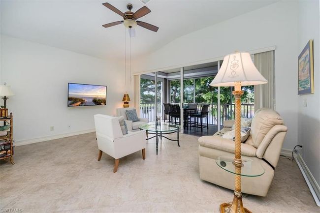 Living room with lofted ceiling and ceiling fan | Image 5