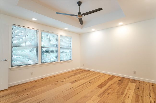 Spare room with a ceiling fan, recessed lighting, a tray ceiling, and light wood-style floors | Image 22