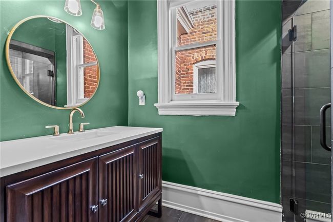 Full bathroom with baseboards, vanity, and a tile shower | Image 26