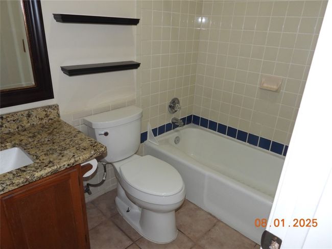 Bathroom featuring vanity, bathing tub / shower combination, and light tile patterned floors | Image 13