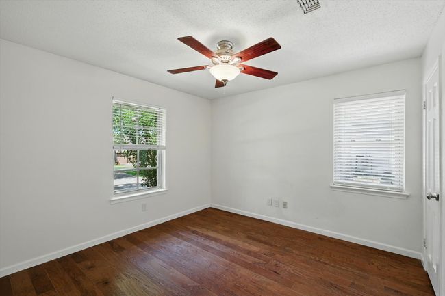 Empty room with ceiling fan, hardwood / wood-style floors, and a textured ceiling | Image 20