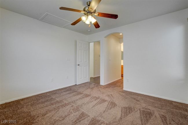 Carpeted spare room featuring baseboards, arched walkways, and a ceiling fan | Image 16